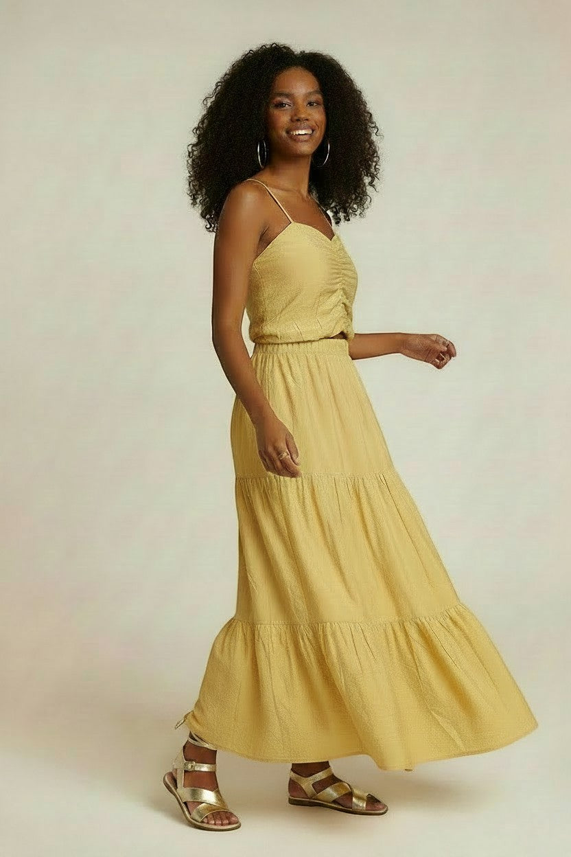 WDC SHOP yellow tiered maxi skirt and ruched cami set on a model with curly hair.